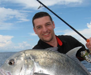 deep sea fishing. boat fishing, lucky fisherman holding a big trevally jack